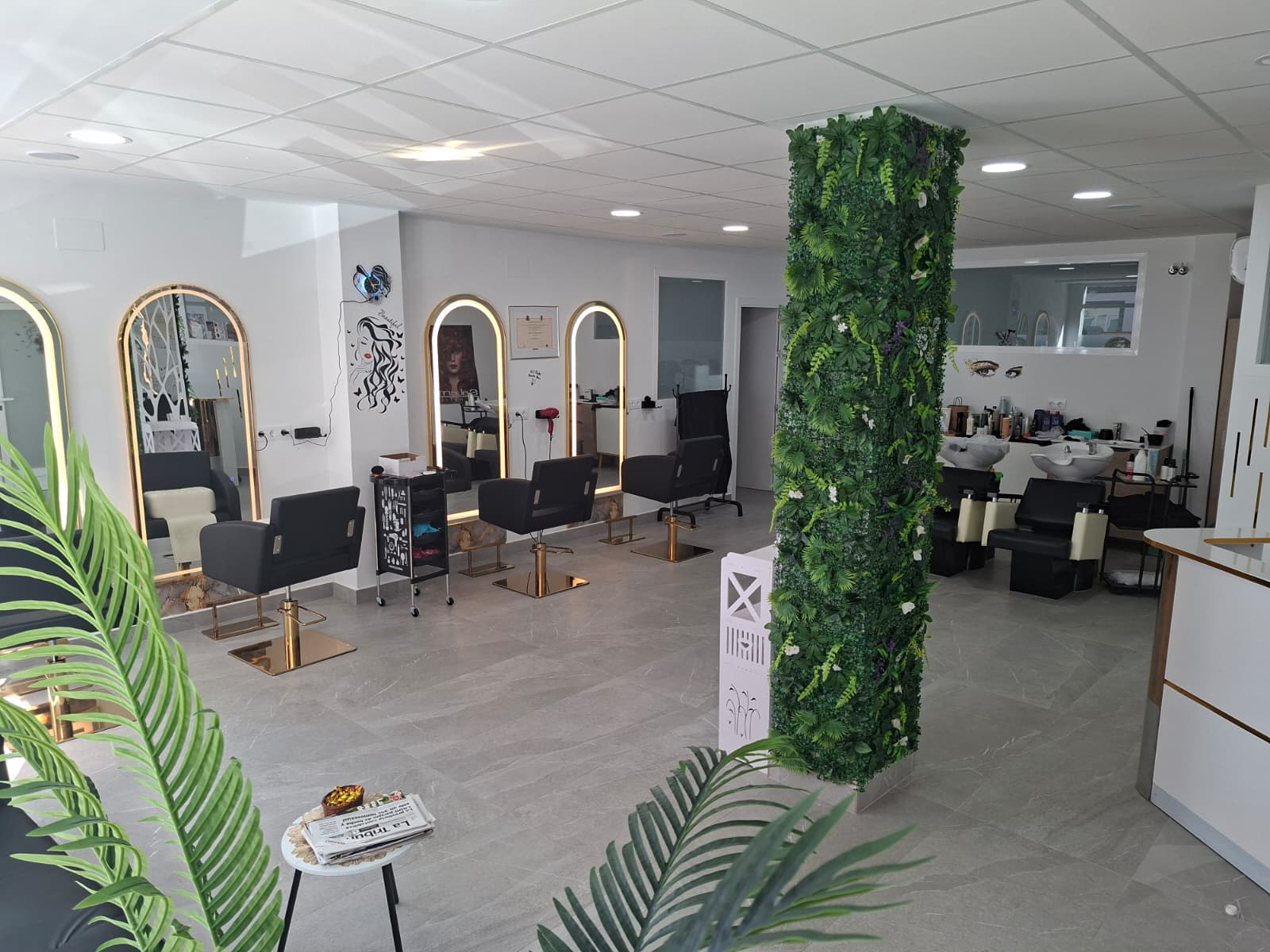 Interior del centro de belleza con puestos de peluquería y detalles dorados